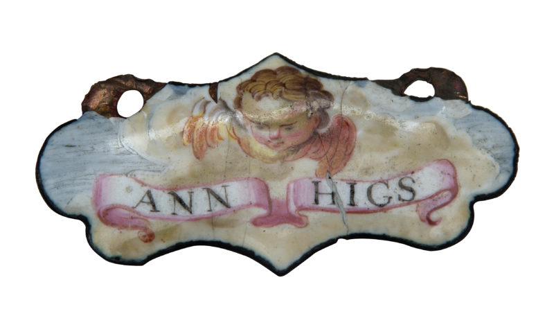 Enamelled pendant decorated with a cherub hovering above the name 